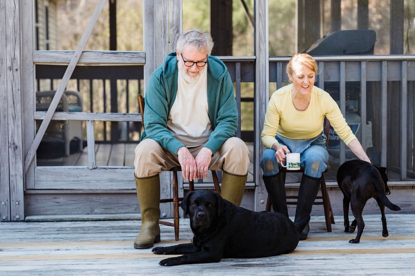 A couple on a porch with their two dogs