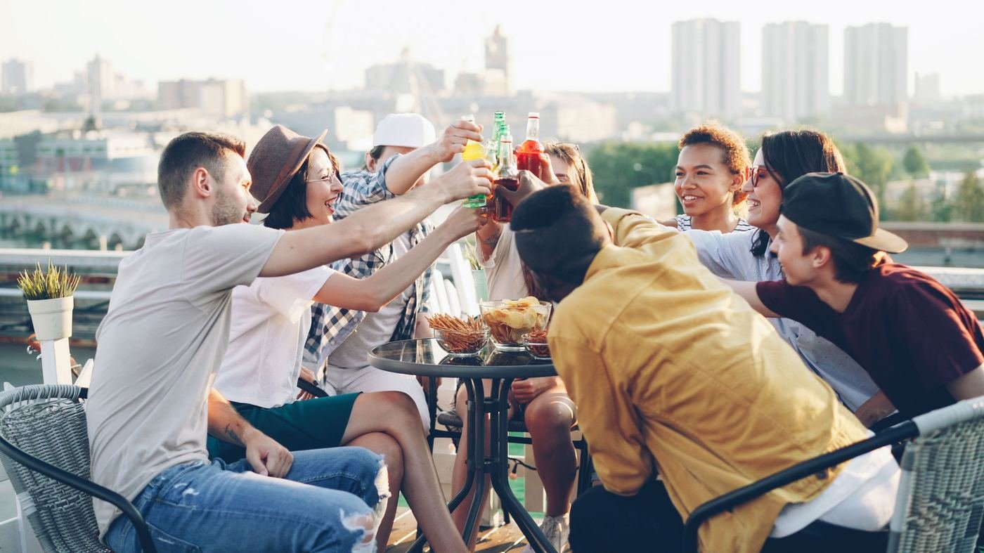 Friends raising a toast on a rooftop at dusk